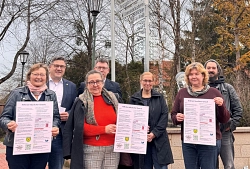 Aushang Notfallplan und Fahne Von Links: Gleichstellungsbeauftragte Undine Rosenwald-Metz, Bürgermeister Ingo Klokemann, Sabine Meyer (Präventionsrat), Joachim Batke (Präventionsrat), Erste Gemeinderätin Jaqueline Gebauer, Kerstin Kohl (Präventionsrat) und Timo Röß (Präventionsrat) präsentieren den Aushang.
